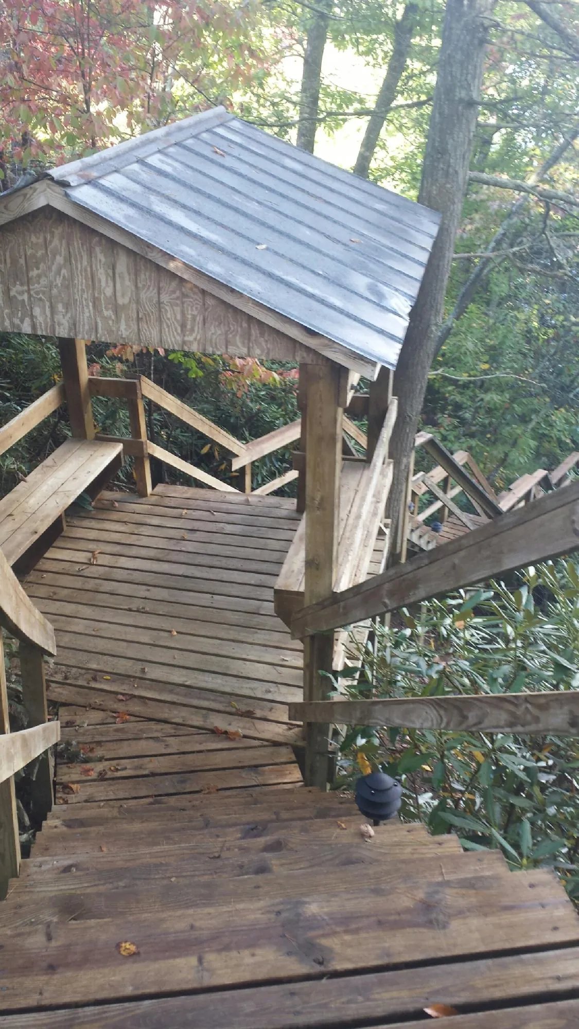 Metal roofed shelter over wooden steps on a wooded walkway — Skylight Repair & Installation work by our crew in Ashton